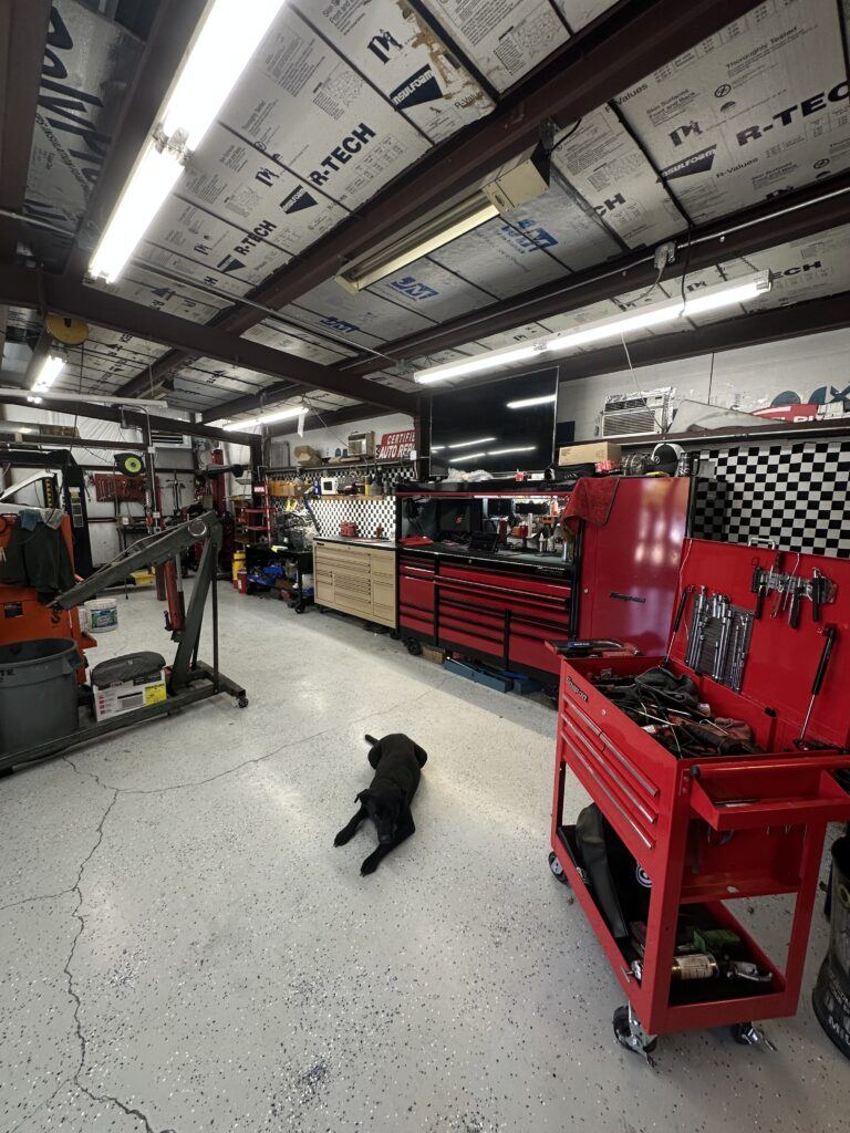 Auto mechanic shop bay with tool boxes and engine lift to provide vehicle repairs