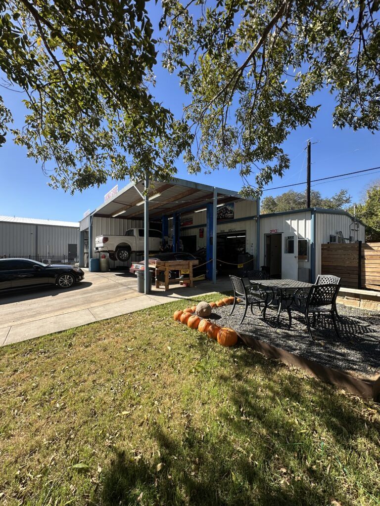 Picture of auto mechanic shop with cars on a hydraulic lift being worked on 